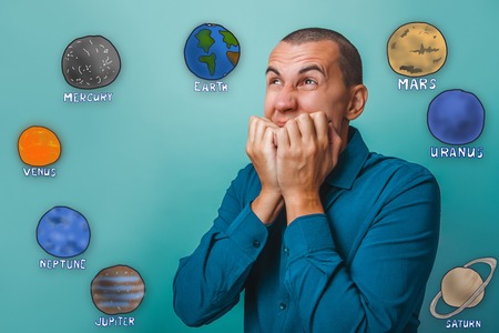 businessman chewing his fingers raised his hands to his mouth and looking towards the inevitability of planets in the solar system astronomyの写真素材