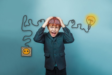 Teen boy screaming businessman holding his head igniter charge charging cord plug wires and sketch infographicsの写真素材