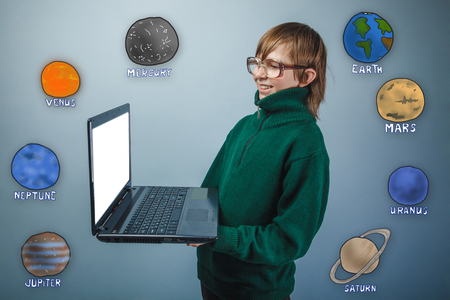 of adolescence boy holding hands and smiling happily plate in green sweater planets of the solar system astronomyの写真素材