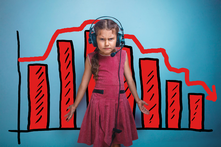 a girl of seven European appearance brunette sad thing keeps fingers on a gray background, discontentの写真素材