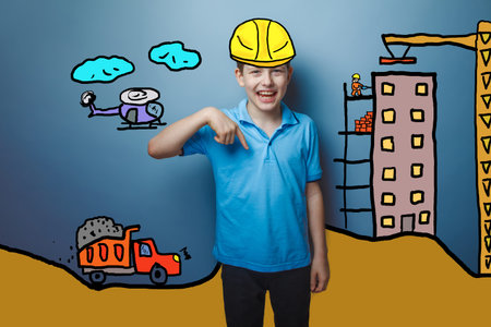 a teenager boy laughing happy down indicates a builder in a helmet of the house under construction...