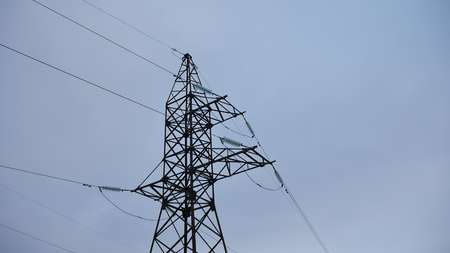 Electrical tower with cables against gray electricity backgroundの写真素材