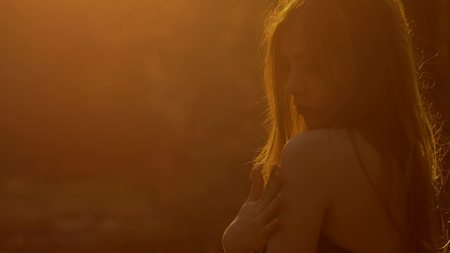 girl stroking his shoulders sexy at sunsetの写真素材