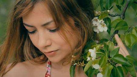 beautiful girl with a blooming branch closeupの写真素材