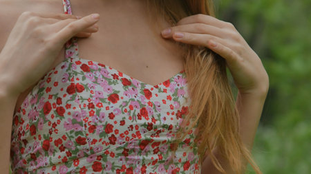 Girl corrects a dress and hair close up in the forestの写真素材