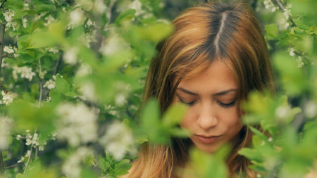 sexy girl looking through the flowering branches