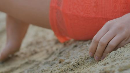 Girls hand pours sand close upの写真素材