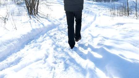 man walking in the snow in the winter forest nature landscape travelの写真素材