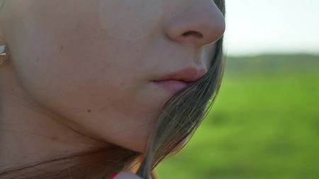Girl lips. Girl is standing on the nature hair touch lifestyle lips. strong windの写真素材
