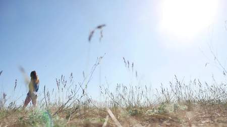 travel. Girl Young woman arms raised enjoying the fresh air in grass nature sunlightの写真素材
