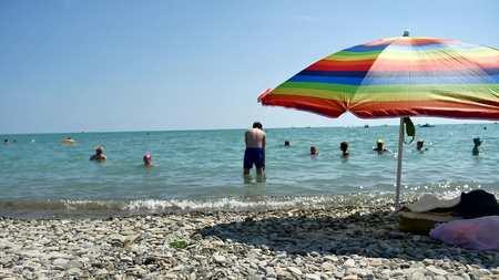 People bathing in the sun, swimming and playing games on the beach. Tourists on the beach from the pebbles sea oceanの写真素材