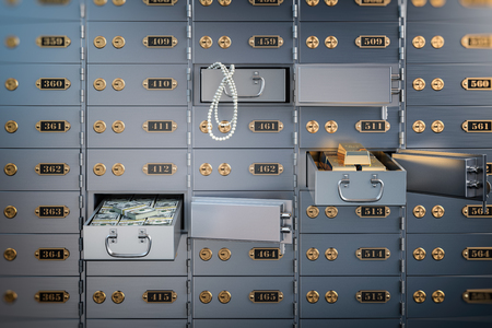 Open safe deposit box with money, jewels and golden ingots.の写真素材