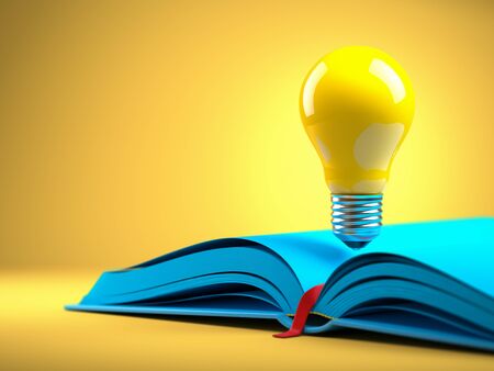 Yellow light bulb on the blue open bookの写真素材