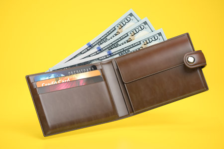 Open leather wallet with dollars and credit cards on yellow background. 3d illustrationの写真素材