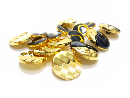 gold and black buttons isolated on whiteの写真素材