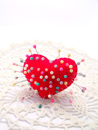 heart with straight pin on white backgroundの写真素材