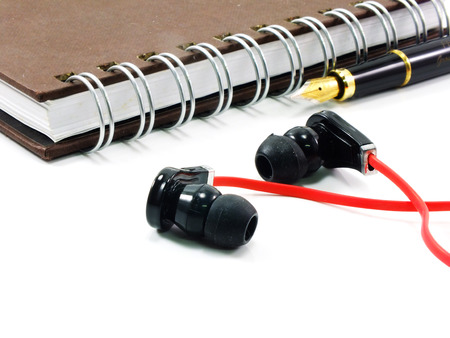 earphones andnote book on white bakgroundの写真素材