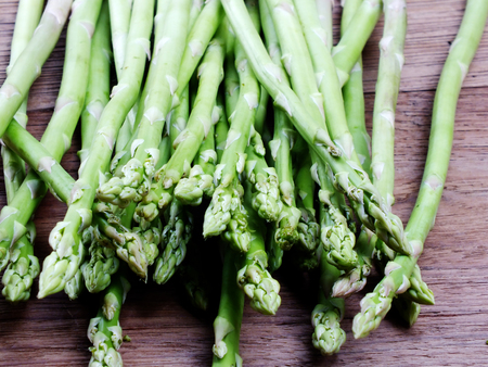 bunch of green asparagus on wooden table backgroundの写真素材