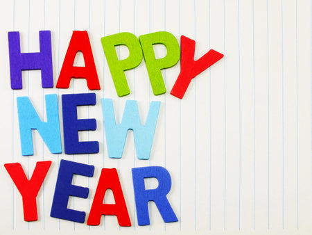 colorful wooden happy new year alphabet on notebook paper background