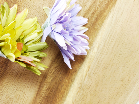 arrangement of artificial gerbera flowers on woodden background useful as invitationsの写真素材