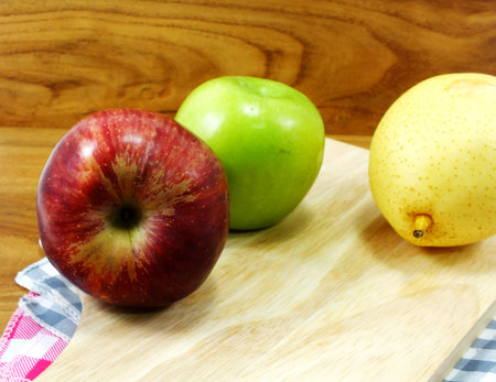 green apple yellow chinese pear and red apple on wooden backgroundの写真素材
