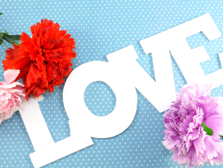 postcard with artificial flowers and tag with words with loveの写真素材