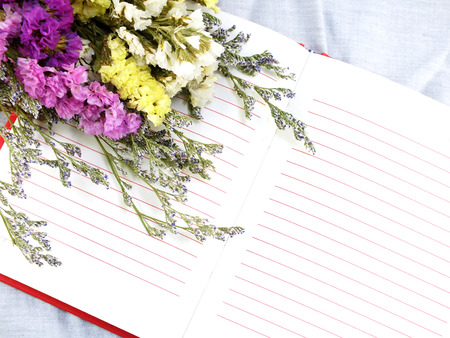 open notebook and beautiful statice flowers bouquet  with space for copyの写真素材