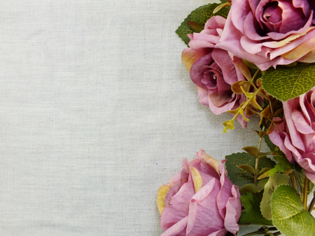 artificial purple rose flowers on linen copy space border backgroundの写真素材