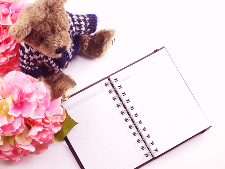 still life with notebook and artificial pink flowersの写真素材