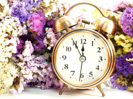 spring time with alarm clock and statice flowers bouquet backgroundの写真素材