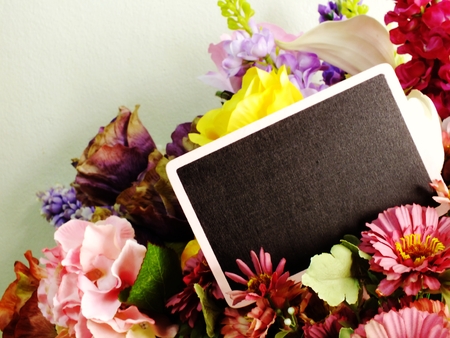 space background with bouquet of flowers and empty wooden tagの写真素材