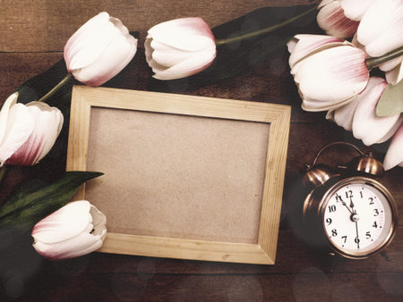 alarm clock with beautiful bouquet of tulips on wooden background