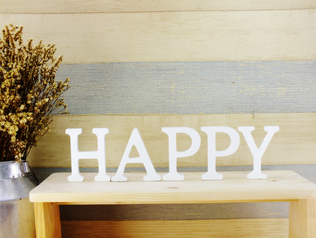 decorative letters word happy with dried flowers on wooden backgroundの写真素材