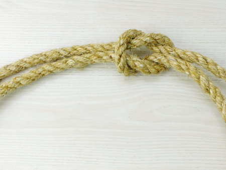 hemp rope knot isolated on wooden background