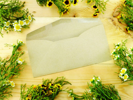 letter envelope greeting card mockup top view with daisy florws decor on wooden background
