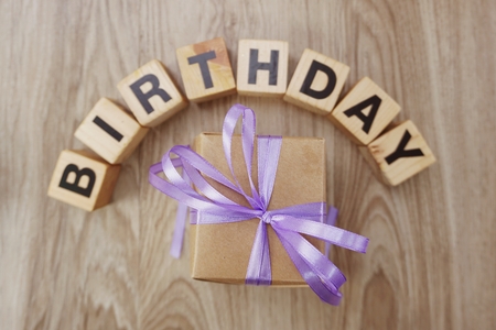 birthday alphabet wooden cube with gift box present on wooden backgroundの写真素材