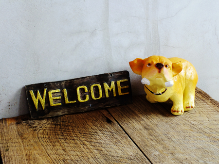 ceramic dog with welcome sign on wooden backgroundの写真素材