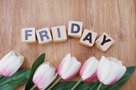 happy friday alphabet letter with flower bouquet on wooden background