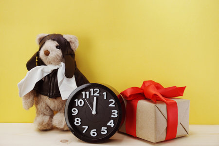 teddy bear and alarm clock with space copy on wooden background