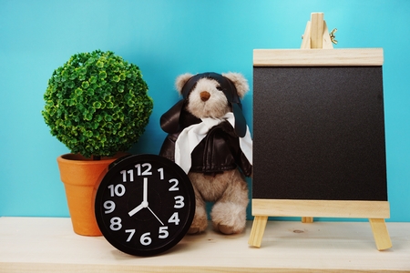 teddy bear and alarm clock with space copy on wooden backgroundの写真素材