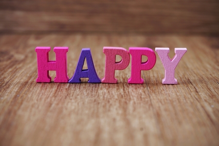 colorful text happy letters alphabet on wooden backgroundの写真素材