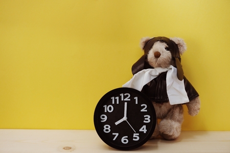teddy bear and alarm clock with space copy on wooden backgroundの写真素材