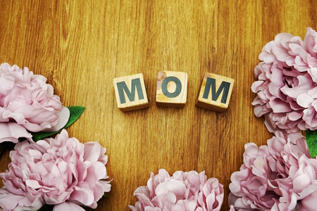 mother's day concept love mom alphabet with flower on wooden backgroundの写真素材