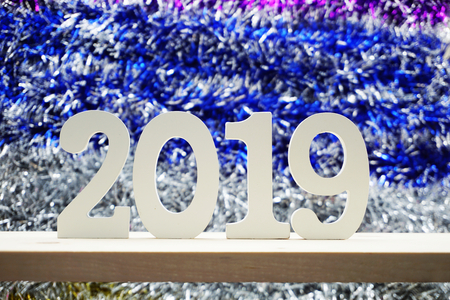 Happy New Year 2019 wooden number on shiny tinsel backgroundの写真素材