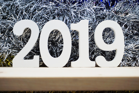 Happy New Year 2019 wooden number on silver shiny tinsel backgroundの写真素材