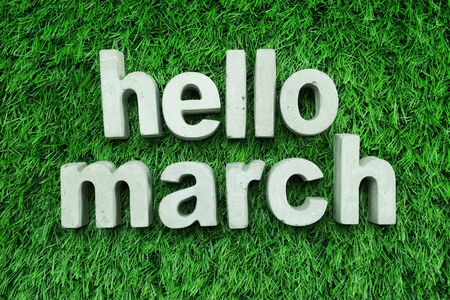 Hello March made from concrete alphabet top view on green grassの写真素材