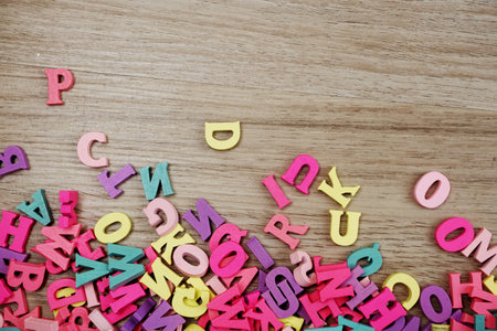 random colorful letterpress alphabet with space copy top view on wooden background