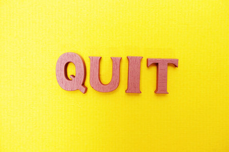 Top view Quit letters alphabet letters on Yellow background