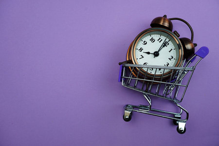 Alarm clock and Mini trolley cart with space copy on purple background