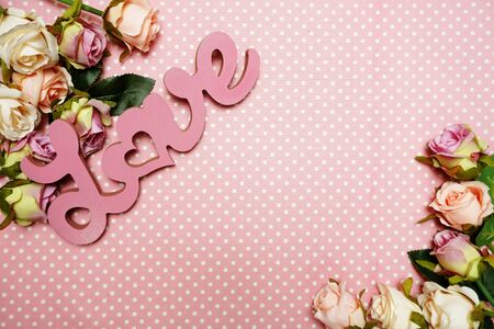 Love word alphabet and Gift box with roses bouquet with space copy on pink polka dot backgroundの写真素材